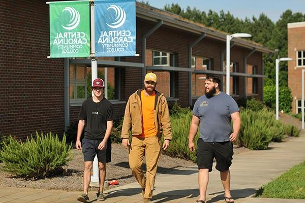 Three student walking through campus 