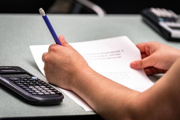 Students hands with paper & calculator 